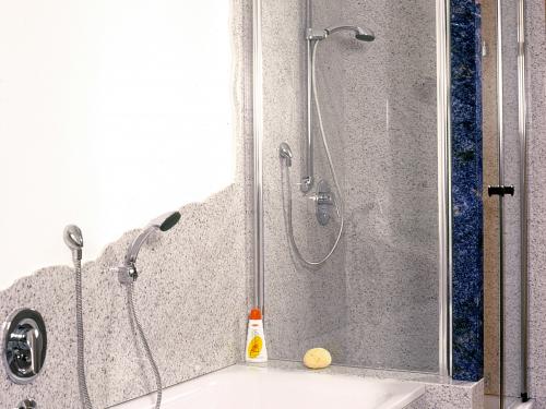 Eingebaute Badewanne mit Bethel White Granit- Fliesen, eingefasst von passenden Granitfliesen, die ein nahtloses und elegantes Design im Badezimmer kreieren. Die glatte, weiße Oberfläche des Granits mit dezenter Maserung verleiht dem Raum ein Gefühl von Luxus und Ruhe.