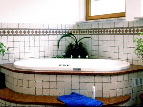 Luxuriöse eingebaute Badewanne, umgeben von Biancone Rosso Verona Marmor, der durch seine markante rote und weiße Maserung auffällt. Die Wanne ist perfekt in den Boden eingelassen und bietet durch ihre einzigartige Farbgebung und hochwertige Materialauswahl ein ästhetisches Highlight im Badezimmer.