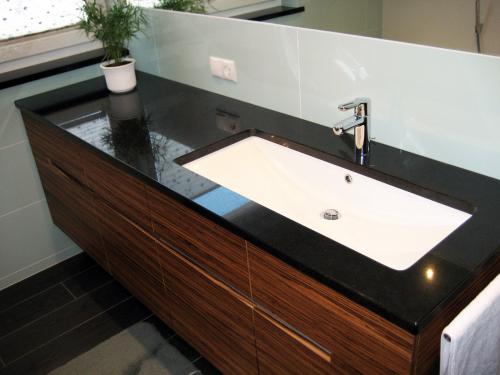 Robuster Waschtisch aus Nero Assoluto Granit, der durch seine tief schwarze Farbe und glatte Oberfläche eine markante Präsenz im Badezimmer schafft. Dieser Waschtisch verkörpert eine moderne Ästhetik und verleiht dem Raum einen Hauch von zeitloser Eleganz und Raffinesse.